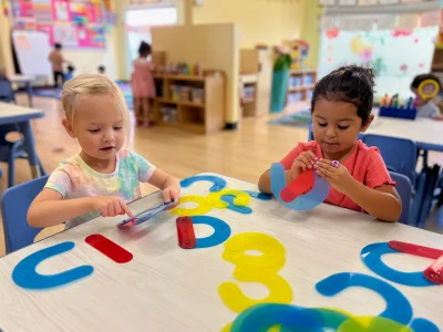 4-year-old Pre-K children at Village Preschool Academy working on academic worksheets at a table preparing for kindergarten