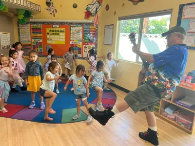 Children playing soccer as part of outdoor sports enrichment at Village Preschool Academy building teamwork and leadership